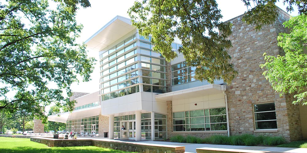 Front glass and stone facade of the FAC on a green and sunny day - Press enter to play