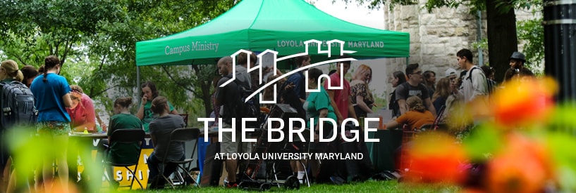 Students congregating around tables at the Student Activities Fair, with flowers in the foreground