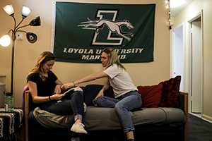 Students in a residence hall common room working on a computer