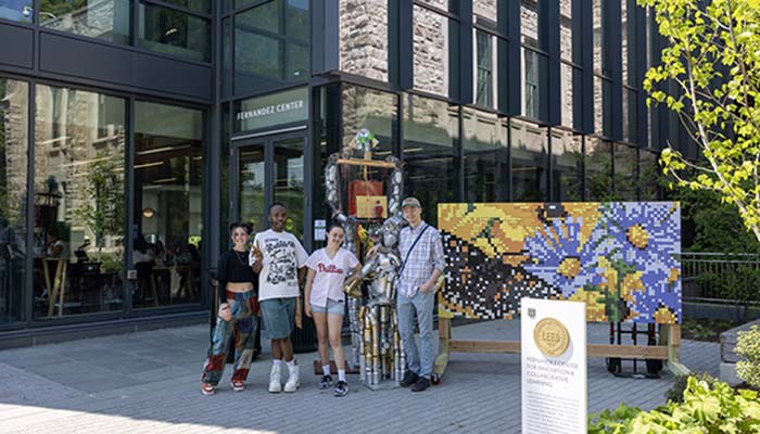 Students stand with art project during Earth Week celebration