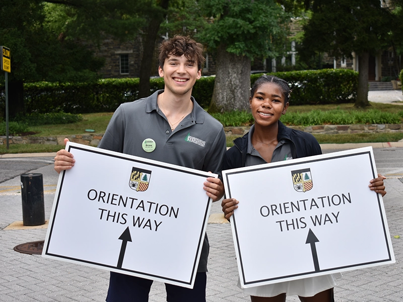 Two students greet new students for Orientation