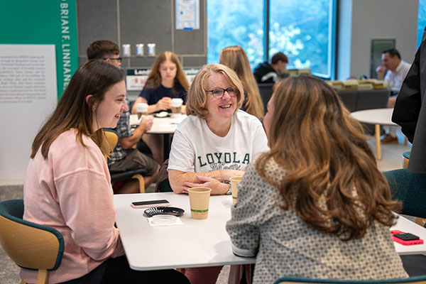 A student meets with two Loyola faculty