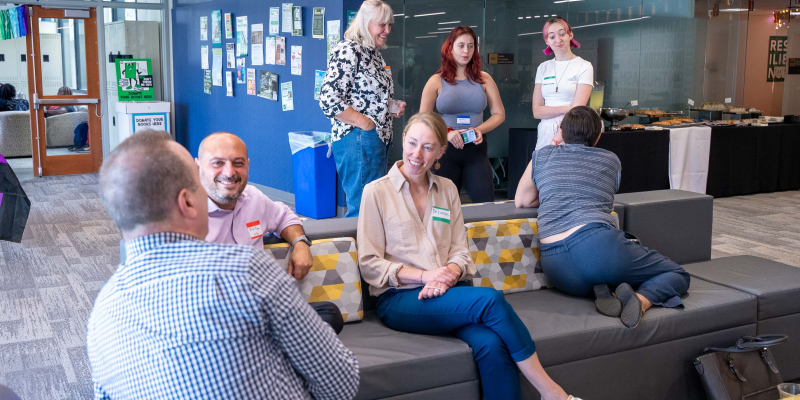 a group of seven people sitting and standing while engaged in conversation at a thrive center event