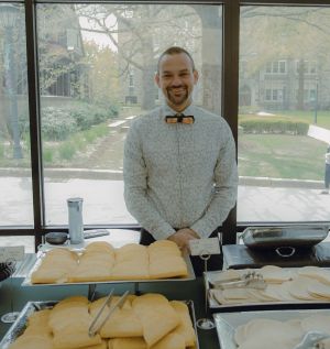 David Tiscione standing behind taco bar at outreach event for affirmative consent