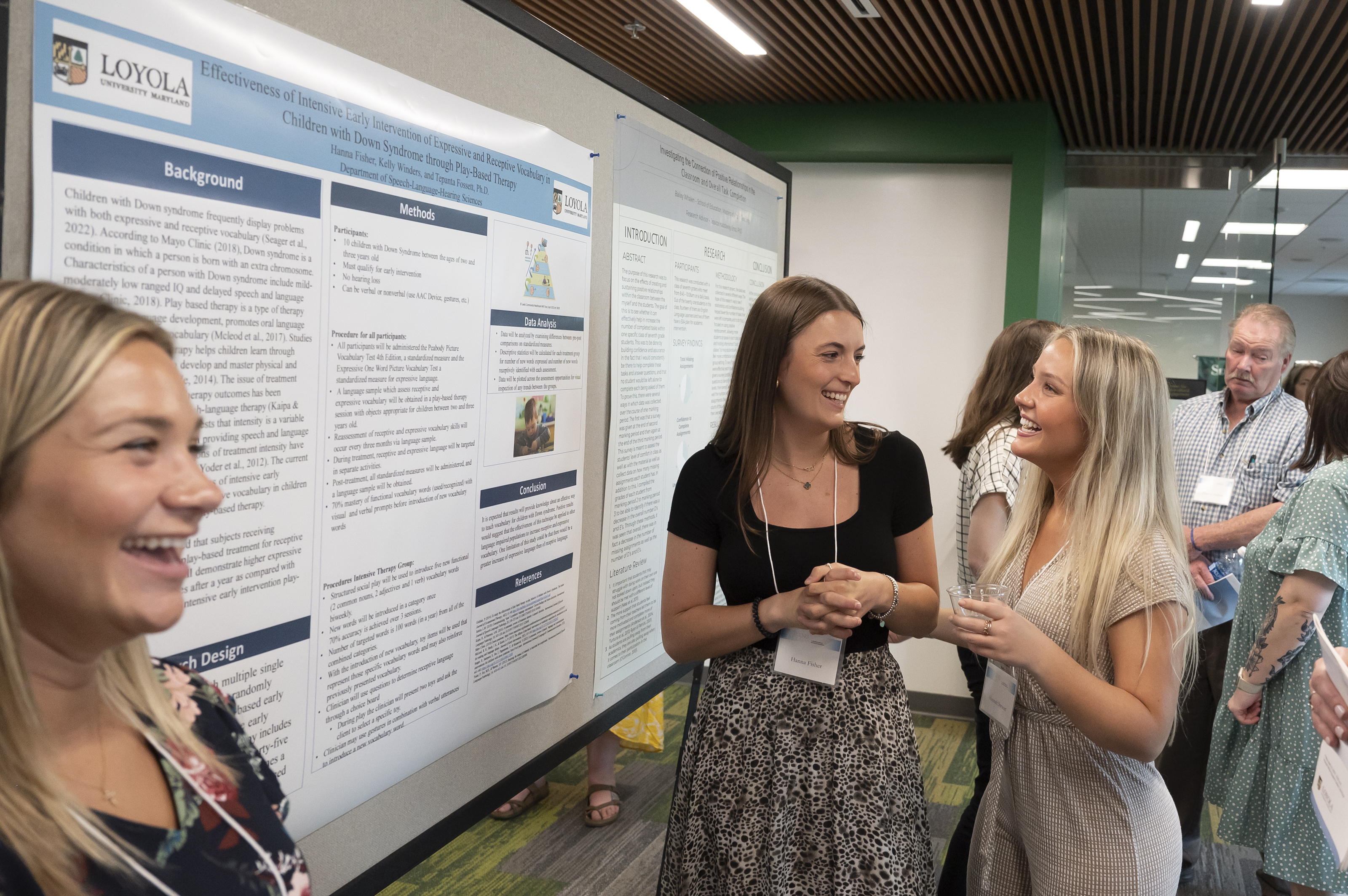 Presenters smiling in front of poster at Emerging Scholars Celebration of Research, Loyola Univ. Maryland