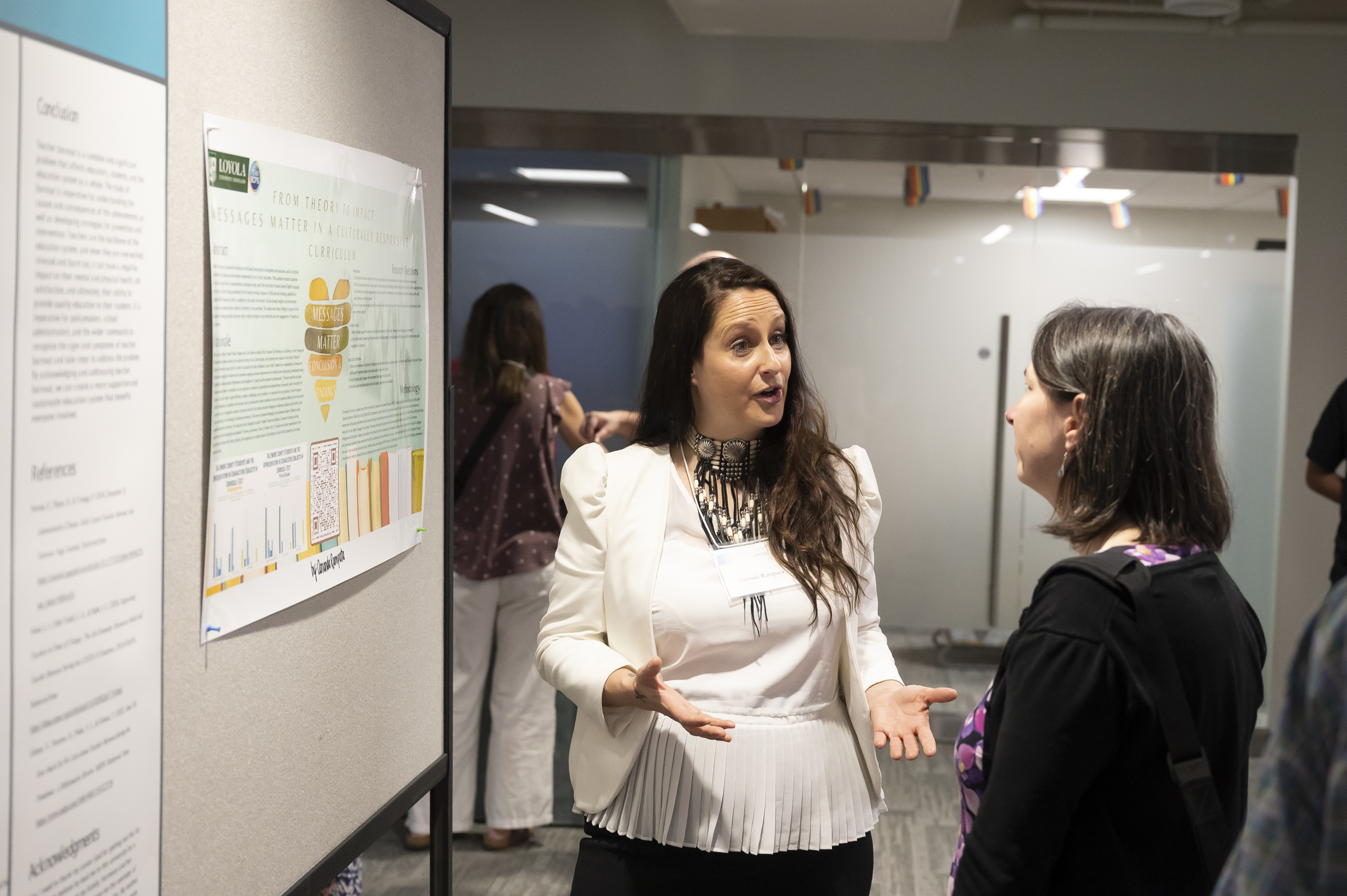 Presenter in discussion with visitor at poster at Emerging Scholars Loyola University Maryland