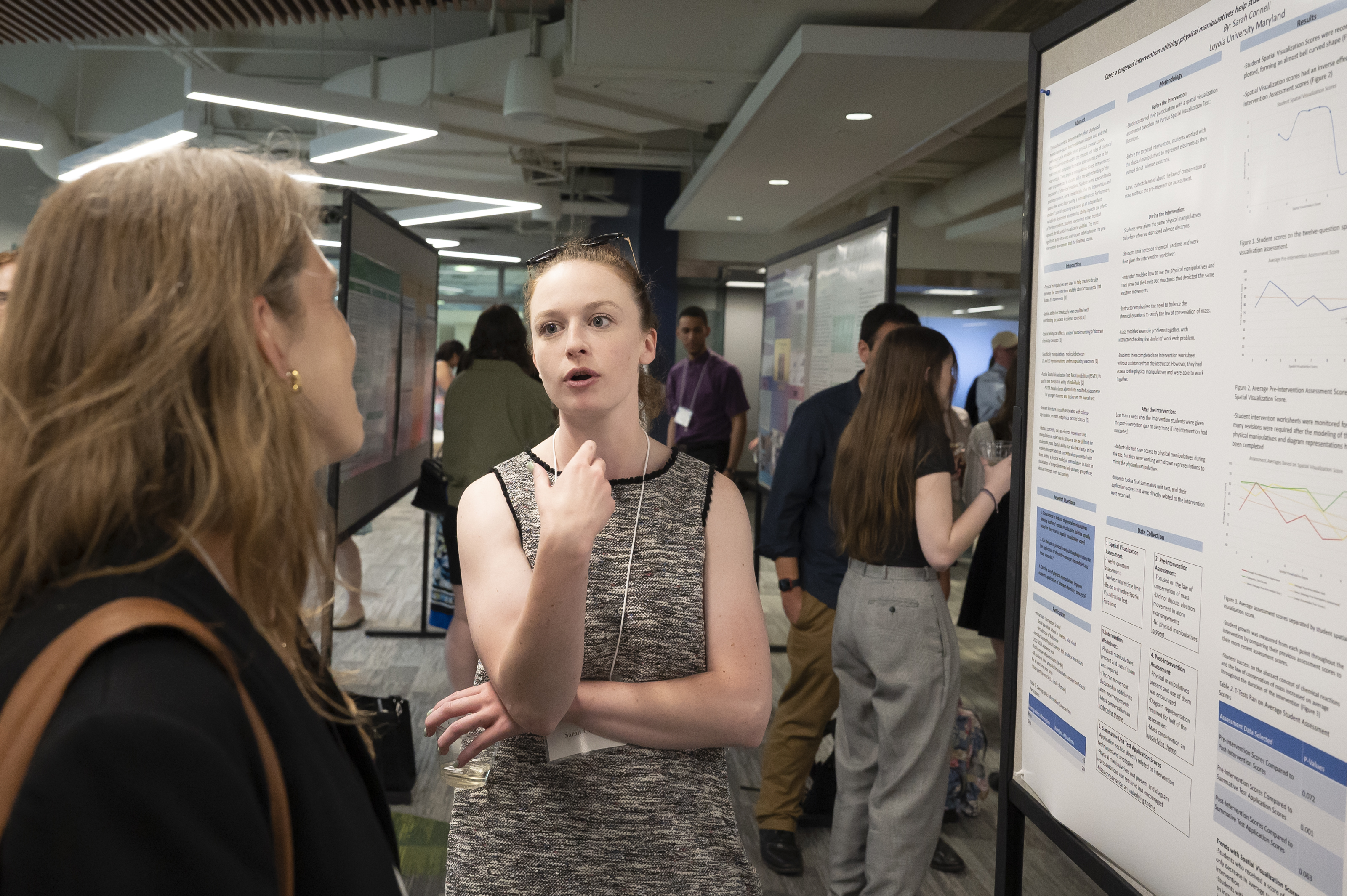 Presenter in discussion with visitor at poster at Emerging Scholars Loyola University Maryland