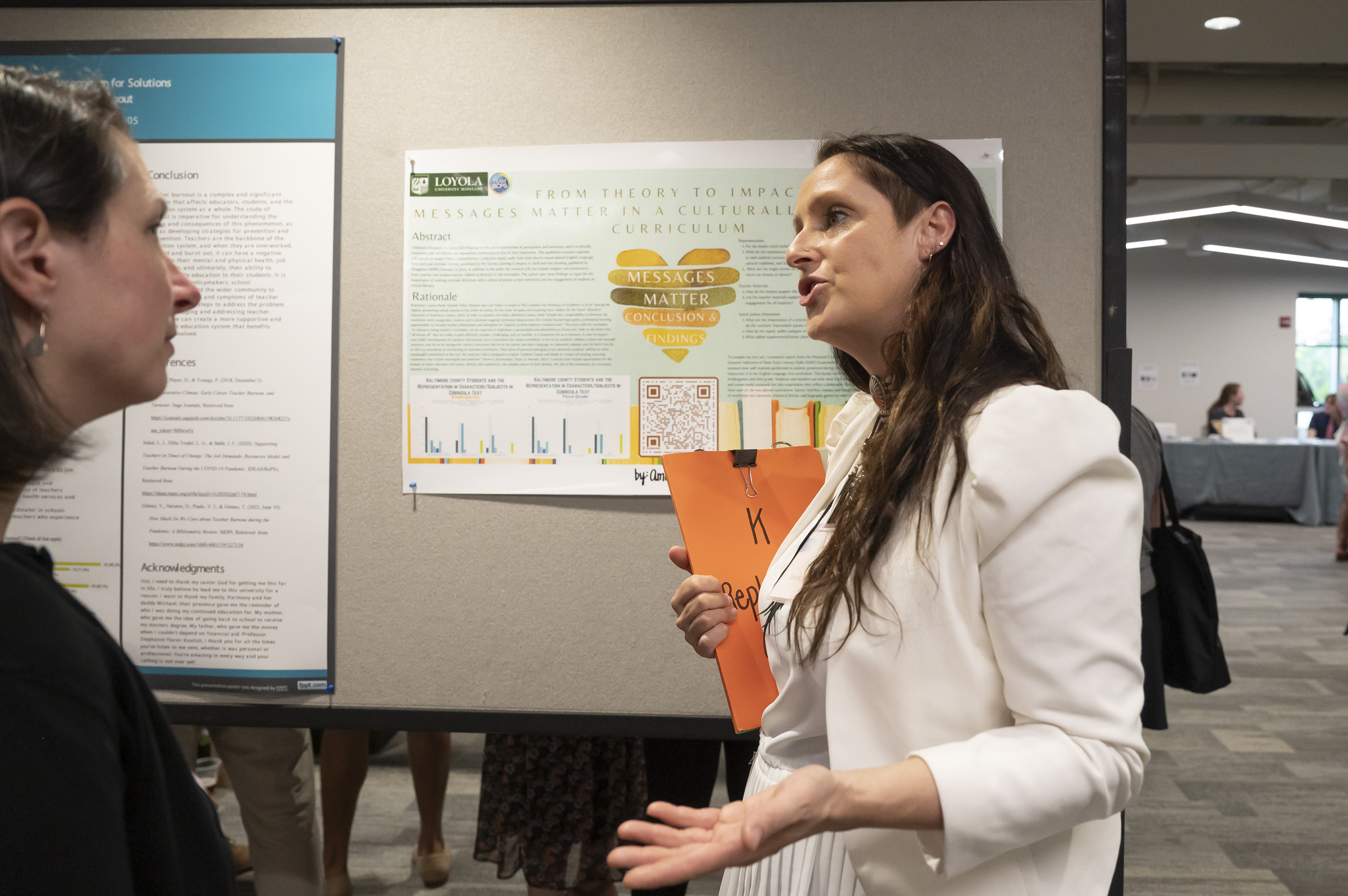 Presenter discusses research findings with professor at Emerging Scholars program at Loyola University Maryland