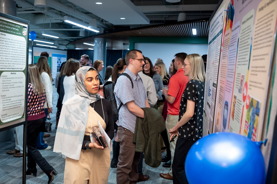 Graduate student examines research poster at Emerging Scholars 2024