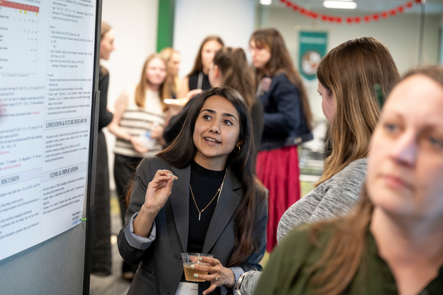 Presenter makes a point about poster at Emerging Scholars Loyola University Maryland