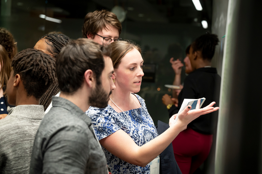 Two graduate students discuss poster at Emerging Scholars 2024