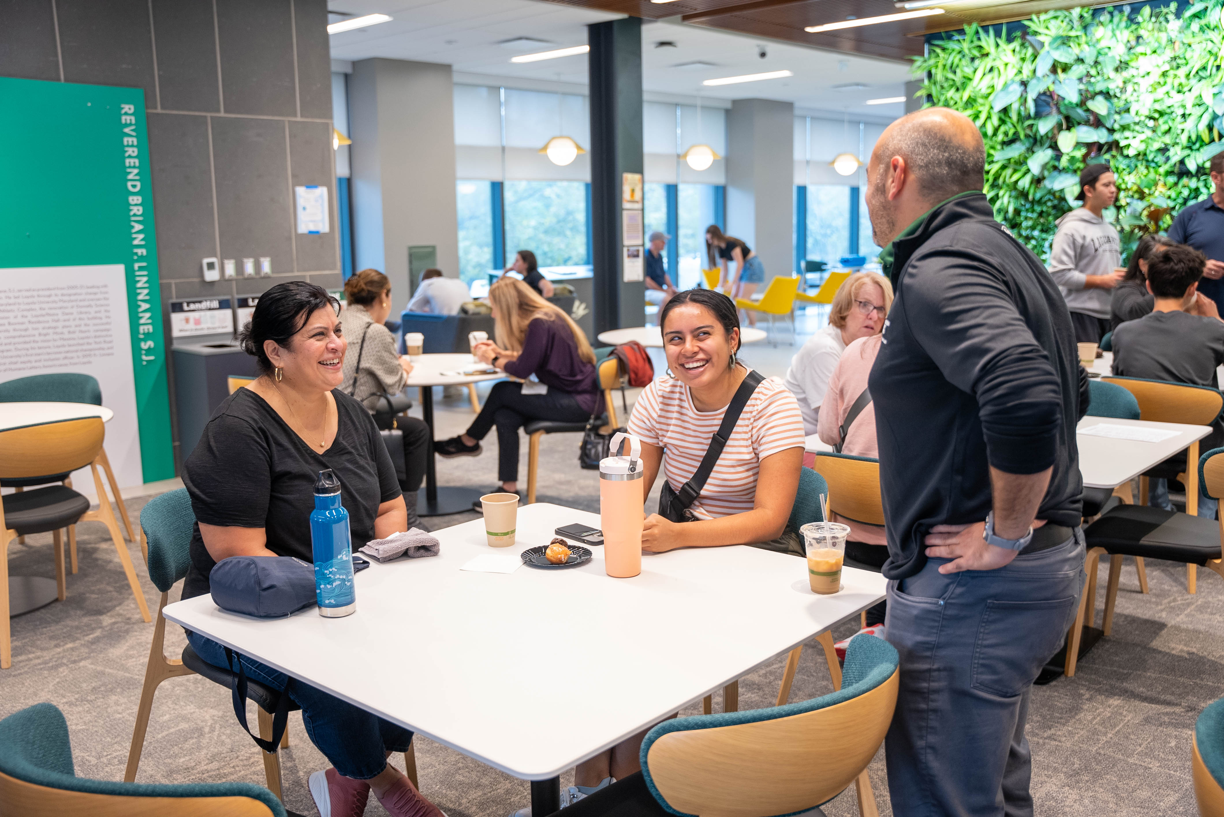 The dean of students chats with a mother and daughter at a table