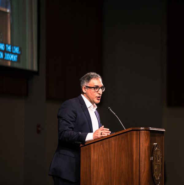 man at lectern screen illuminated
