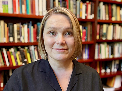 Headshot of Stephanie McCarter in a library with short blonde hair