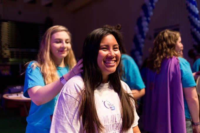 Long haired student about to get hair cut at Relay for Life