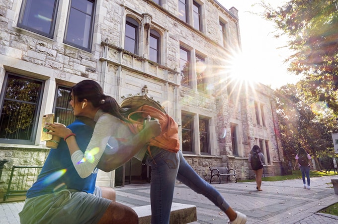 Two students greet each other with a hug outside Beatty Hall