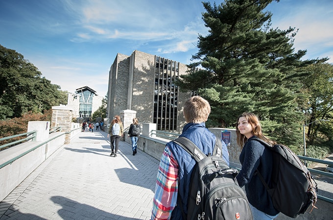 Students walk down the pedestrian bridge on Charles Street