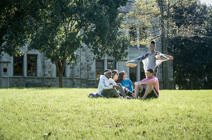 A group of students sitting on a blanket on the Quad