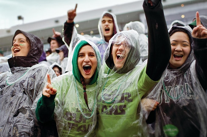 A group of students wearing raincoats in the stands at the Ridley Athletic Complex