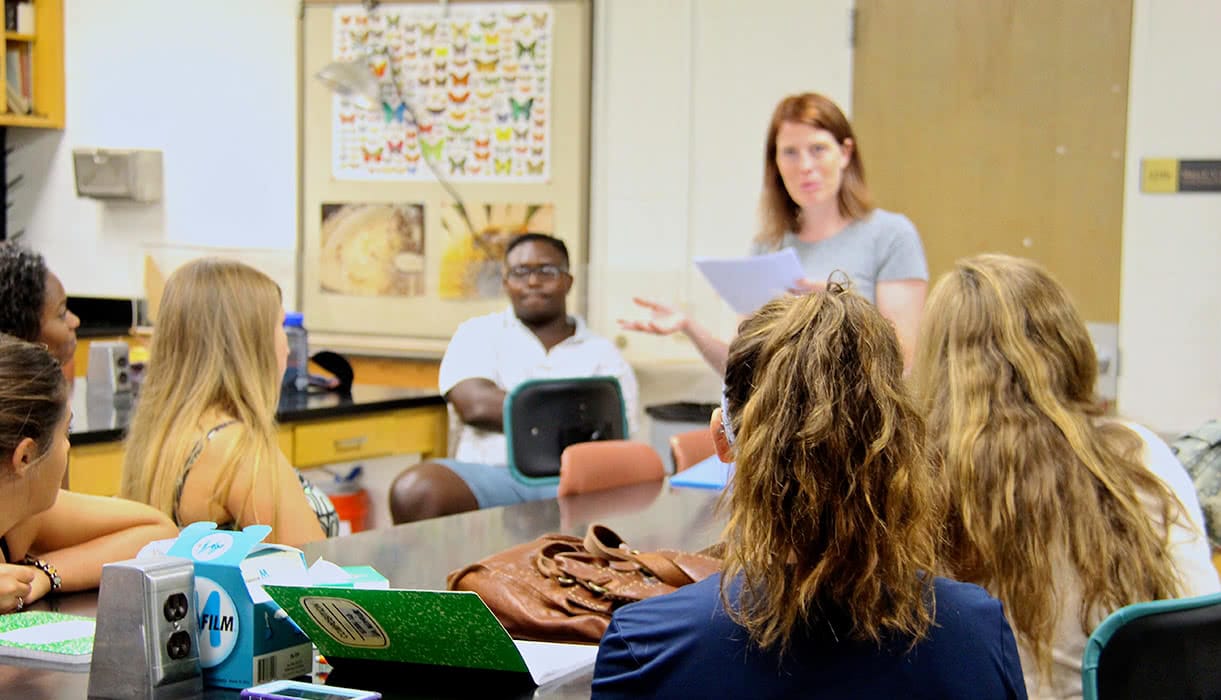 A professor talking to a class in a biology lab