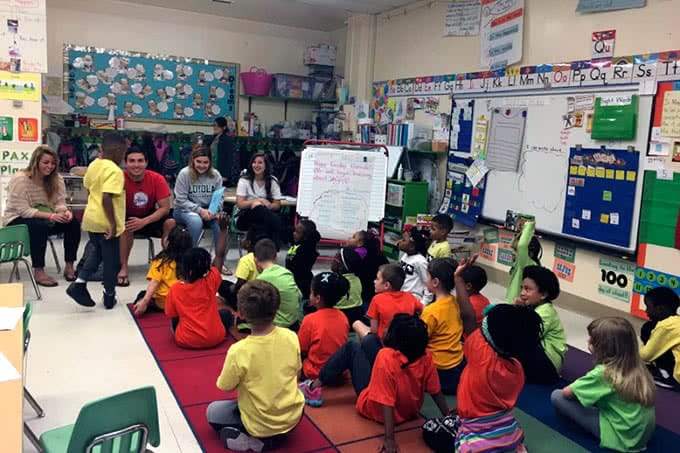 College students in front of a class of elementary students