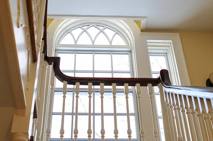 A light-filled window sits above a turning staircase