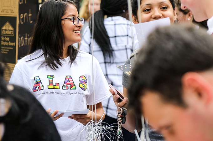 A student advertises for a Thrive Center club at the student activities fair.