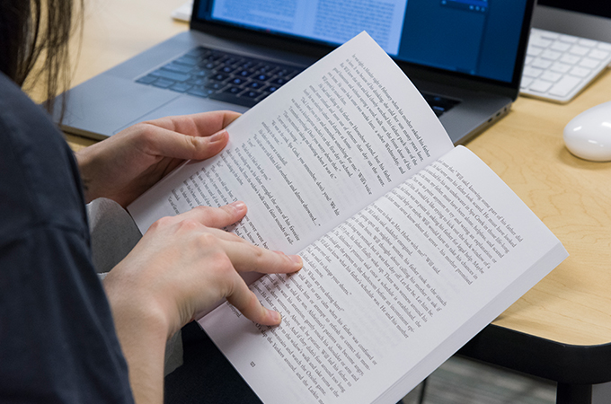 Student flipping through a finished book.