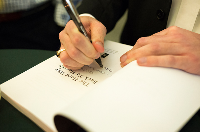 Student author Karl Dehmelt, ’18 signs a copy of his book.