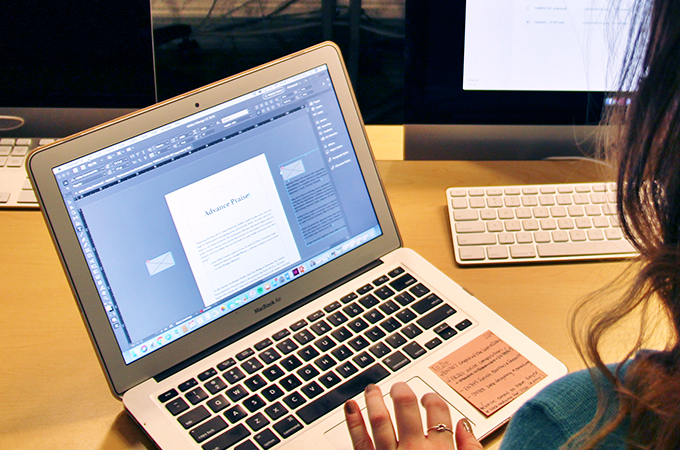 Student typesetting a book on a laptop.