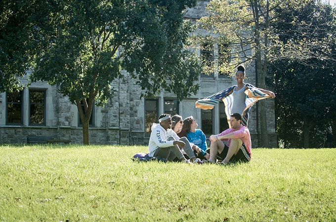 A group of students sitting on blankets on the Quad on a bright and sunny day