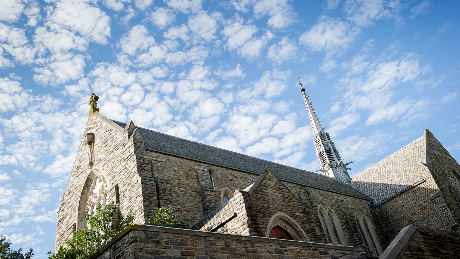 The Alumni Chapel exterior with a bright and cloudy sky above it