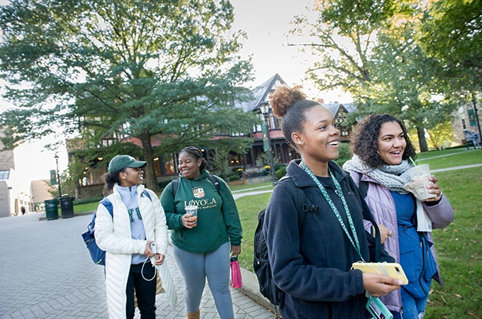 A group of students walking and smiling on the Quad