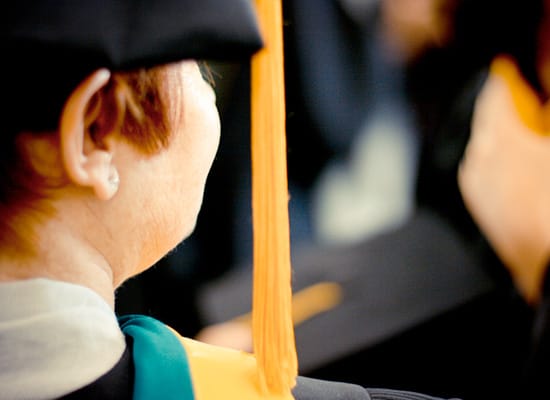 A view from behind of a student's head with tassel hanging from her commencement cap