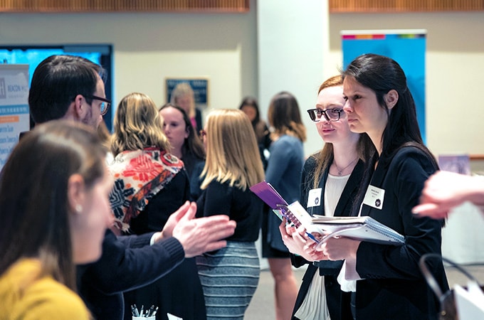 Students at a career fair talking with employers