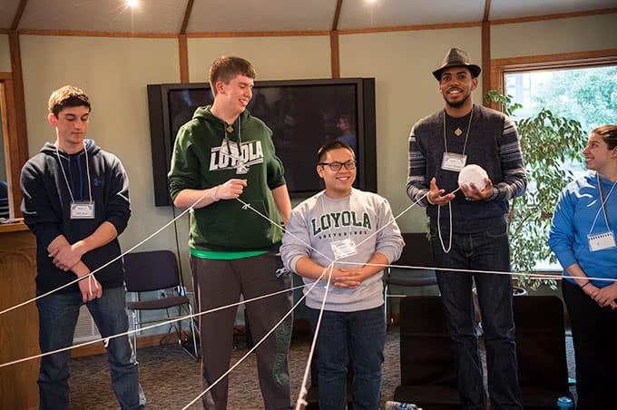 Students holding a string to create a web-like structure