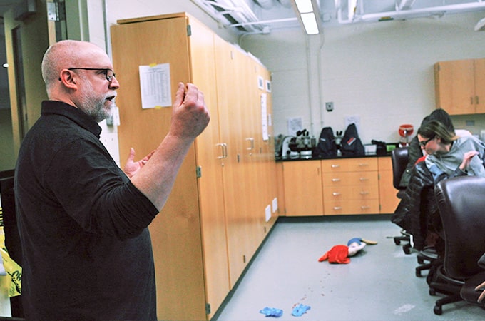 A faculty member explains a mock crime scene.