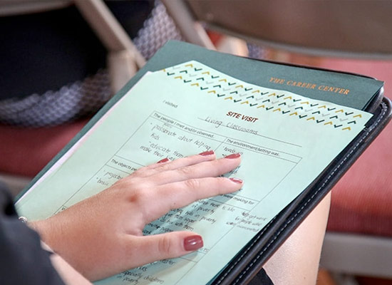 Photo of a student holding their hand over a folder