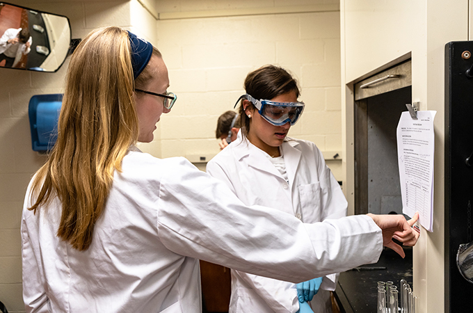 Hannah, ’20, assists a student in breaking down the report.