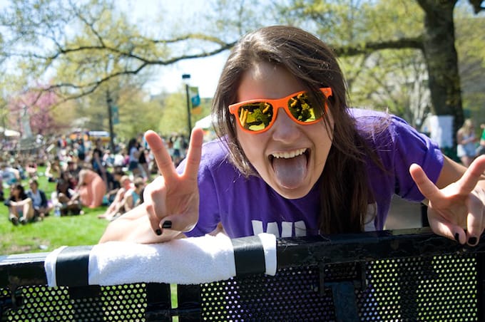 A close-up of a student smiling with her tongue out