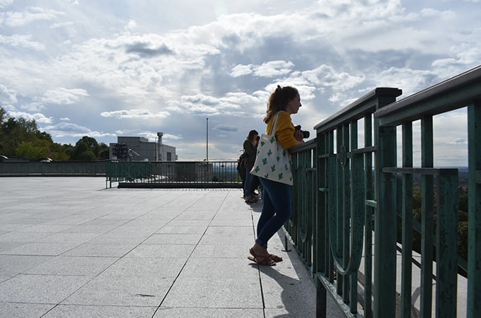 Loyola students leaning against fence and taking picture from their vantage point high above Montreal