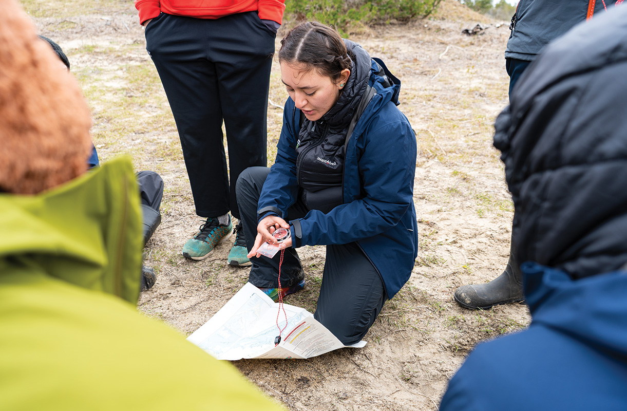 OAE leader demonstrates how to shoot a bearing on a map.