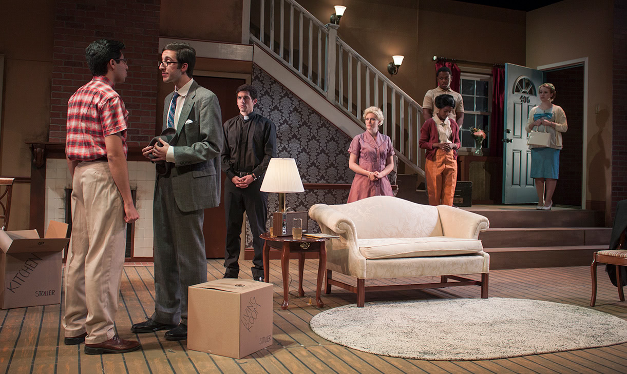 Students on stage in a living room set in the late 50s or 60s