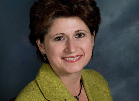 Mary Cina Chalawsky, ’84 smiles in her professional portrait.