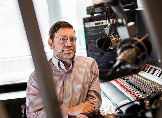 John Devecka in the studio, leaning at his chair.