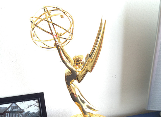 Suzanne's Emmy Award next to a black and white photo of Loyola's humanities manor.