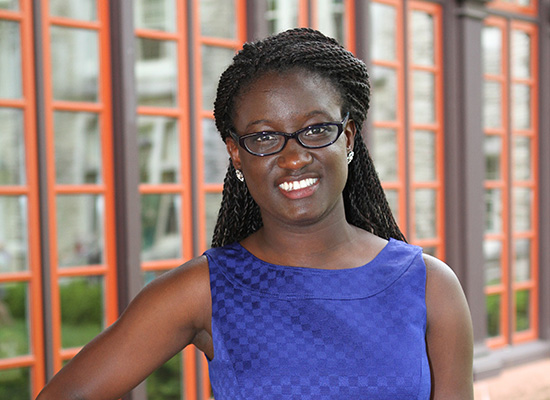 Serwaa stands on the humanities manor porch with hand on hip.