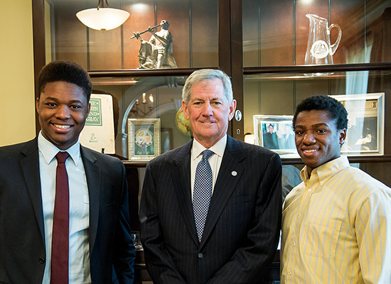 Cohran, Thomas, and a fellow student smile in professional attire.