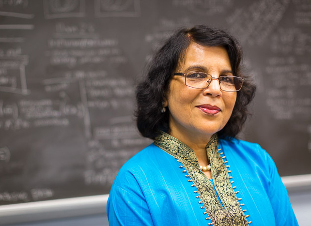 Dipa Sarkar-Dey in her classroom, with blackboard behind her.