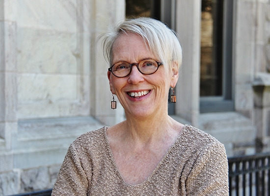 Portrait of Barbara Vann outside a stone building.